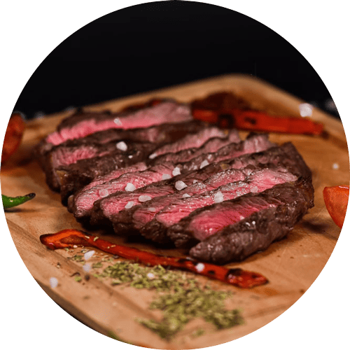 Das Bild zeigt verlockende Steakvariationen, auf einem Holzbrett platziert, mit Gemüse – kreativ als einladender Button für kulinarische Vielfalt.