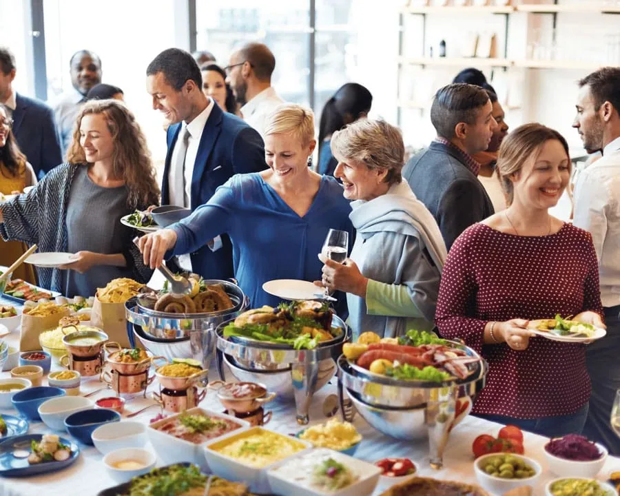 Das Bild zeigt ein reichhaltiges Buffet auf einer Party, an dem sich die Gäste bedienen, und greift das Thema „Partyservice in Radebeul“ auf.